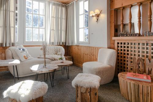 een woonkamer met een bank, een stoel en tafels bij Le Chalet d'Antoine - Centre de Megève in Megève