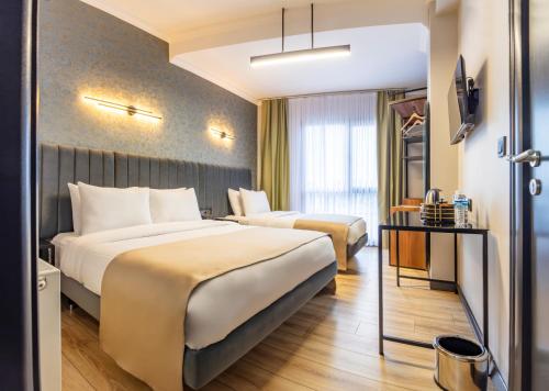 a hotel room with two beds and a television at Lenora Airport Hotel & İstanbul Airport in Arnavutköy