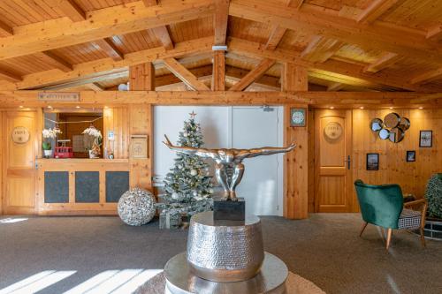 een woonkamer met een kerstboom en een standbeeld bij Le Chalet d'Antoine - Centre de Megève in Megève