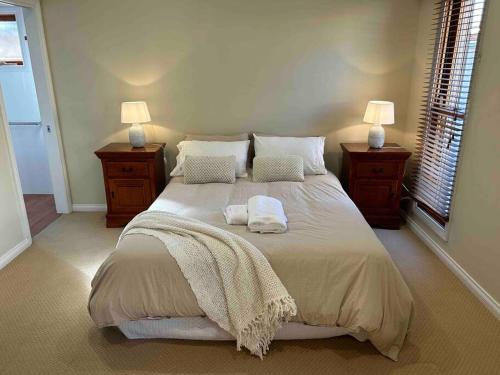 a bedroom with a large bed with two towels on it at Grand retreat in peaceful street in Wodonga