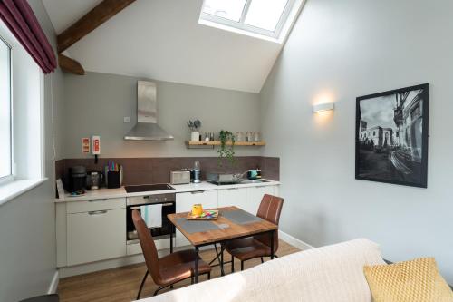 cocina y sala de estar con mesa y sillas en High Street Town House, en Mánchester