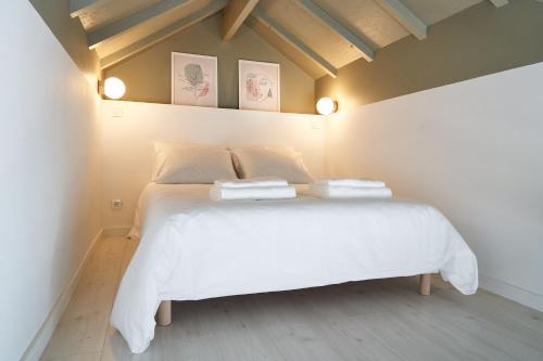 a bedroom with a white bed with two towels on it at Brito Capelo 183 in Matosinhos