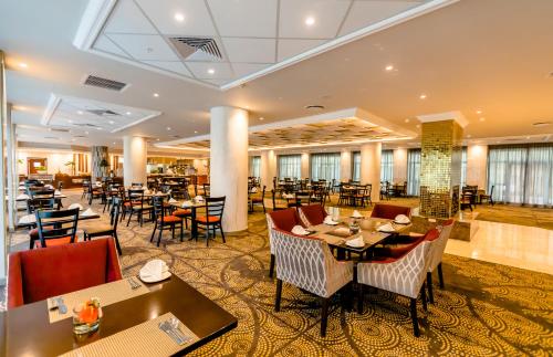 hotelowy hol ze stołami i krzesłami oraz restauracja w obiekcie Southern Sun Sandton w mieście Johannesburg