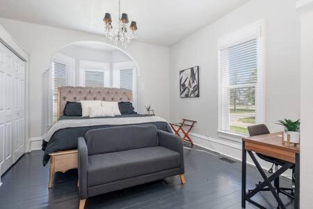 Schlafzimmer mit einem Bett, einem Schreibtisch und einem Stuhl in der Unterkunft Beautiful downstairs 1bed 1bth charmer- Pet Friendly in Michigan City