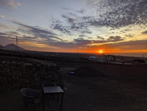 een zonsondergang met een bank en een tafel op de voorgrond bij B Ensuite Appartment con Zona de Patio in Arrecife