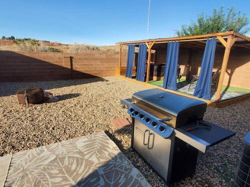 una barbacoa en un patio con una casa en I Deal Lake Powell Home 3BR, Jacuzzi, BBQ, Firepit, en Page