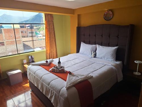 - une chambre avec un grand lit et une grande fenêtre dans l'établissement Chaska valle Inn, à Urubamba