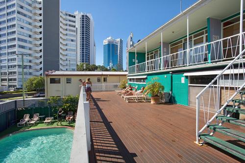 ein Gebäude mit einer Terrasse und einem Pool in der Unterkunft Backpackers In Paradise 18-35 Hostel in Gold Coast