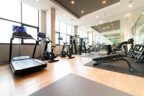 a gym with several treadmills and cardio machines at ON City Hotel in Cheonan