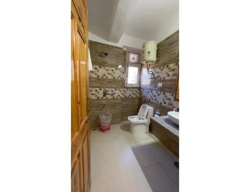 a bathroom with a toilet and a sink at Pine Shadow Retreat, Manali in Manāli