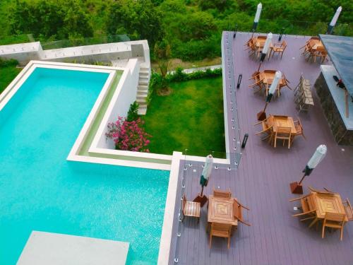 een terras met tafels en een zwembad bij VILLA VALITO in Kuta Lombok