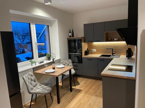 a kitchen with a table and chairs in a kitchen at Lake & Town Apartments Klagenfurt in Klagenfurt