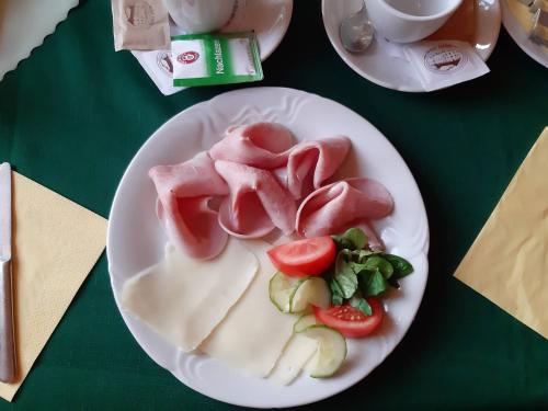 un plato de comida con carne y verduras en una mesa en Rybí Dům, en Kocobedz