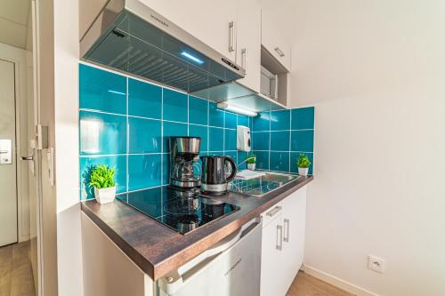 una cucina con piastrelle blu sul muro di Break & Home Paris Italie Porte de Choisy a Ivry-sur-Seine