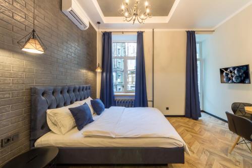 1 dormitorio con 1 cama grande y pared de ladrillo en Self Check-in Apartments Maidan Area, en Kiev