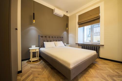 Un dormitorio con una cama grande y una ventana en Self Check-in Apartments Maidan Area, en Kiev