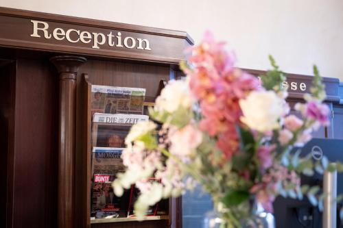 un vase de fleurs assis devant un magasin dans l'établissement Parkhotel 1901 Mannheim, à Mannheim