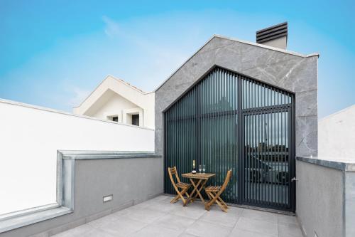 a patio with a table and chairs on a house at Live in Aveiro in Aveiro