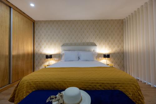 a bedroom with a large bed with two hats on it at Live in Aveiro in Aveiro