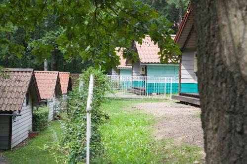 uma cerca em frente a uma casa com um quintal em Waldidylle - Bungalows an der Talsperre Kriebstein em Kriebstein