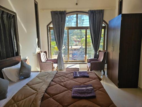 een slaapkamer met een groot bed en een groot raam bij Seven Villa with Swimming pool in Panchgani