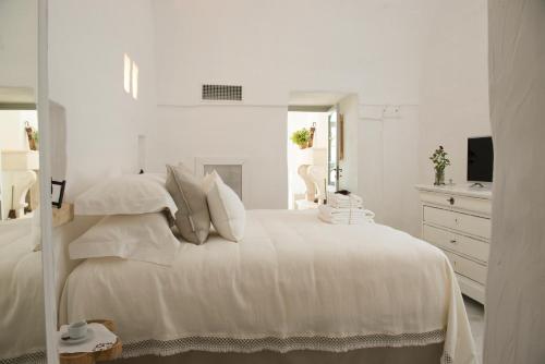 Dormitorio blanco con cama blanca y vestidor en Masseria Le Torri, en Polignano a Mare