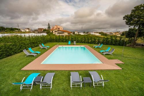 un gruppo di sedie intorno alla piscina di GOLDNATURE a Gondomar