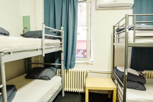 Zimmer mit 3 Etagenbetten und einem Fenster in der Unterkunft HOSTEL SPORT BUCHAREST in Bukarest