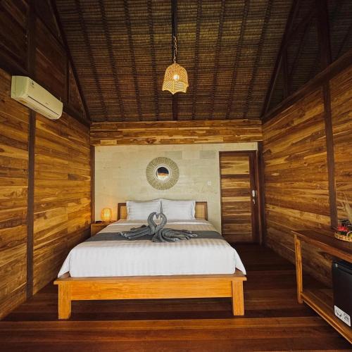 1 dormitorio con 1 cama en una habitación con paredes de madera en Uma Pantai Seseh, en Canggu