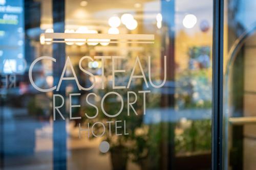 Hotel & Aparthotel Casteau Resort Mons Soignies في Casteau: علامة في نافذة فندق منتجع التجزئة