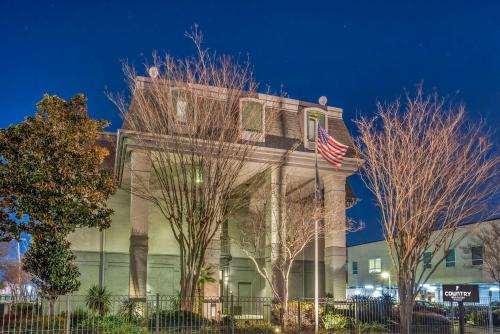 メテリーにあるCountry Inn & Suites by Radisson, Metairie New Orleans , LAのアメリカ旗の建てられた建物