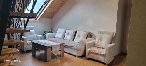 a living room with a couch and two chairs and a table at Levanto in Mtskheta