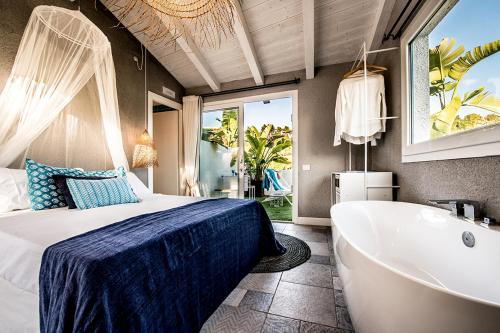 a bedroom with a bed and a bathtub and a tub at CapoBlu Hotel in Pula