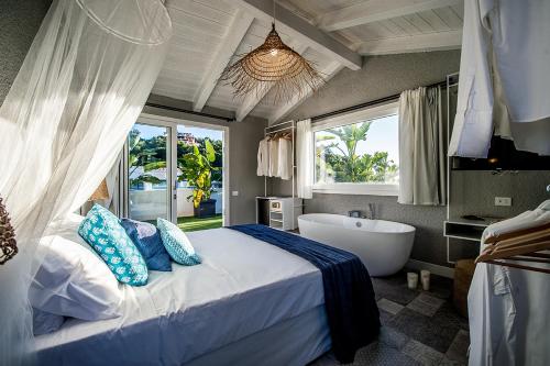 a bedroom with a bed and a tub and a window at CapoBlu Hotel in Pula