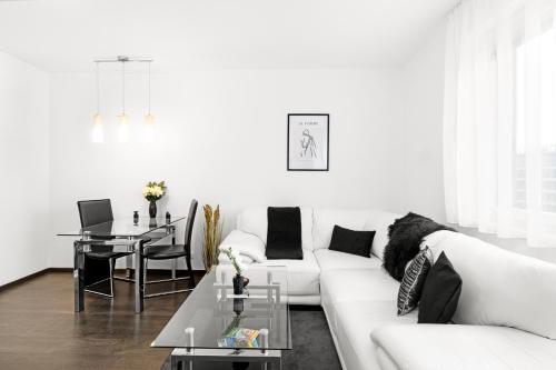 BNB New Beautiful Apartment in the Center of Ostrava with option Garage Parking في Moravská Ostrava: غرفة معيشة بيضاء مع أريكة بيضاء وطاولة