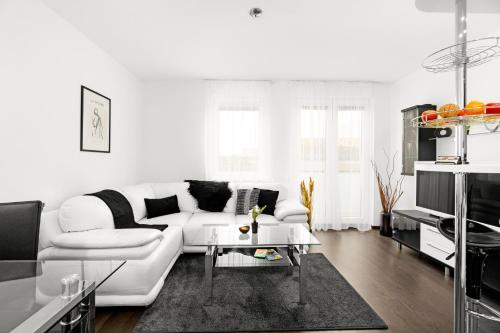 BNB New Beautiful Apartment in the Center of Ostrava with option Garage Parking في Moravská Ostrava: غرفة معيشة بيضاء مع أريكة بيضاء وطاولة