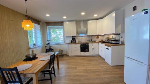 une cuisine avec des placards blancs et une table en bois dans l'établissement Japandi apartamentai, à Kaunas