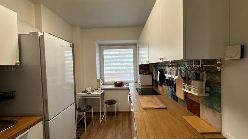 Il comprend une cuisine avec des placards blancs et du parquet. dans l'établissement Japandi apartamentai, à Kaunas