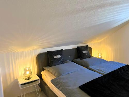 una camera da letto con un letto con cuscini sopra di Zentrale Ferienwohnung am Buhlschen Park in Deidesheim a Deidesheim