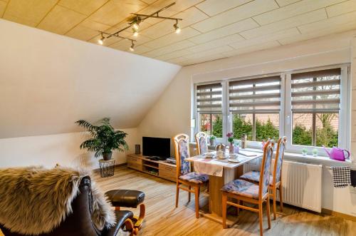 een eetkamer met een tafel en een groot raam bij Ferienwohnung Utkiek in Ihlow