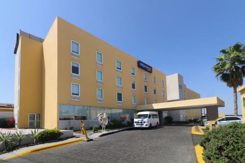 un hôtel avec une camionnette blanche garée devant. dans l'établissement City Express by Marriott Nuevo Laredo, à Nuevo Laredo