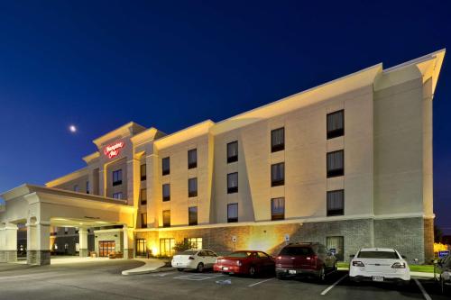 ein Hotel mit Autos auf einem Parkplatz in der Unterkunft Hampton Inn Ft Wayne in Fort Wayne