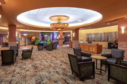 een lobby met stoelen en tafels en een kroonluchter bij Embassy Suites Loveland Conference Center in Loveland