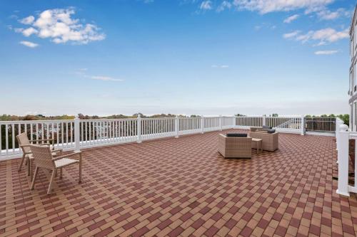 a patio with chairs and a couch on a balcony at Hampton Inn Cape Cod Canal in Buzzards Bay