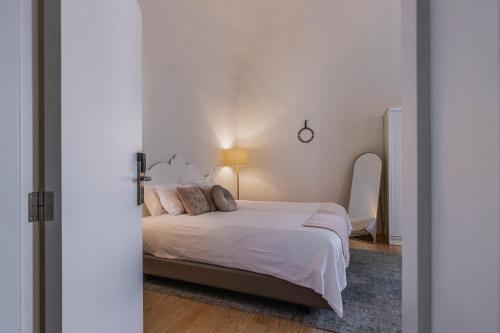 een slaapkamer met een bed met witte lakens en kussens bij Templo Boutique Hotel in Évora