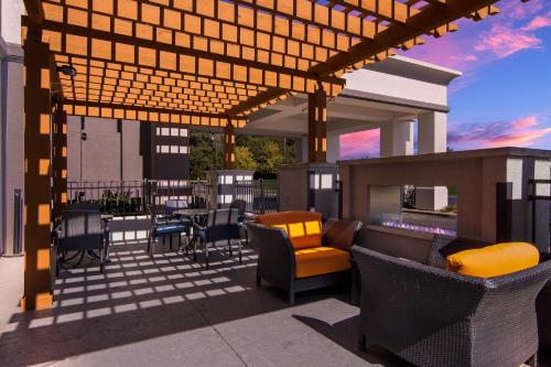 patio z krzesłami, stołem i kominkiem w obiekcie Hampton Inn & Suites Schererville w mieście Schererville