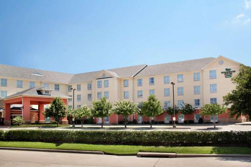 スタッフォードにあるHomewood Suites by Hilton Houston Stafford Sugar Landの目の前に木々が生い茂る大きな建物