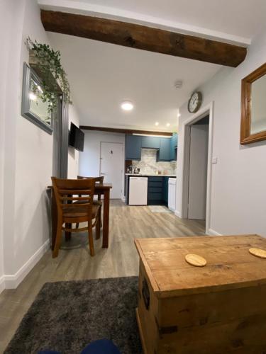 a living room with a table and a kitchen at The Old Barn one bedroom apartment in Overton in Overton