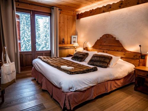 a bedroom with a large bed in a cabin at Les Chalets de la Serraz in La Clusaz