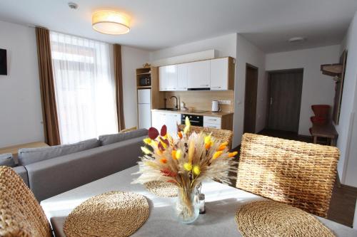 a living room with a table with a vase of flowers at Apartmány Lipno-Hory in Horní Planá